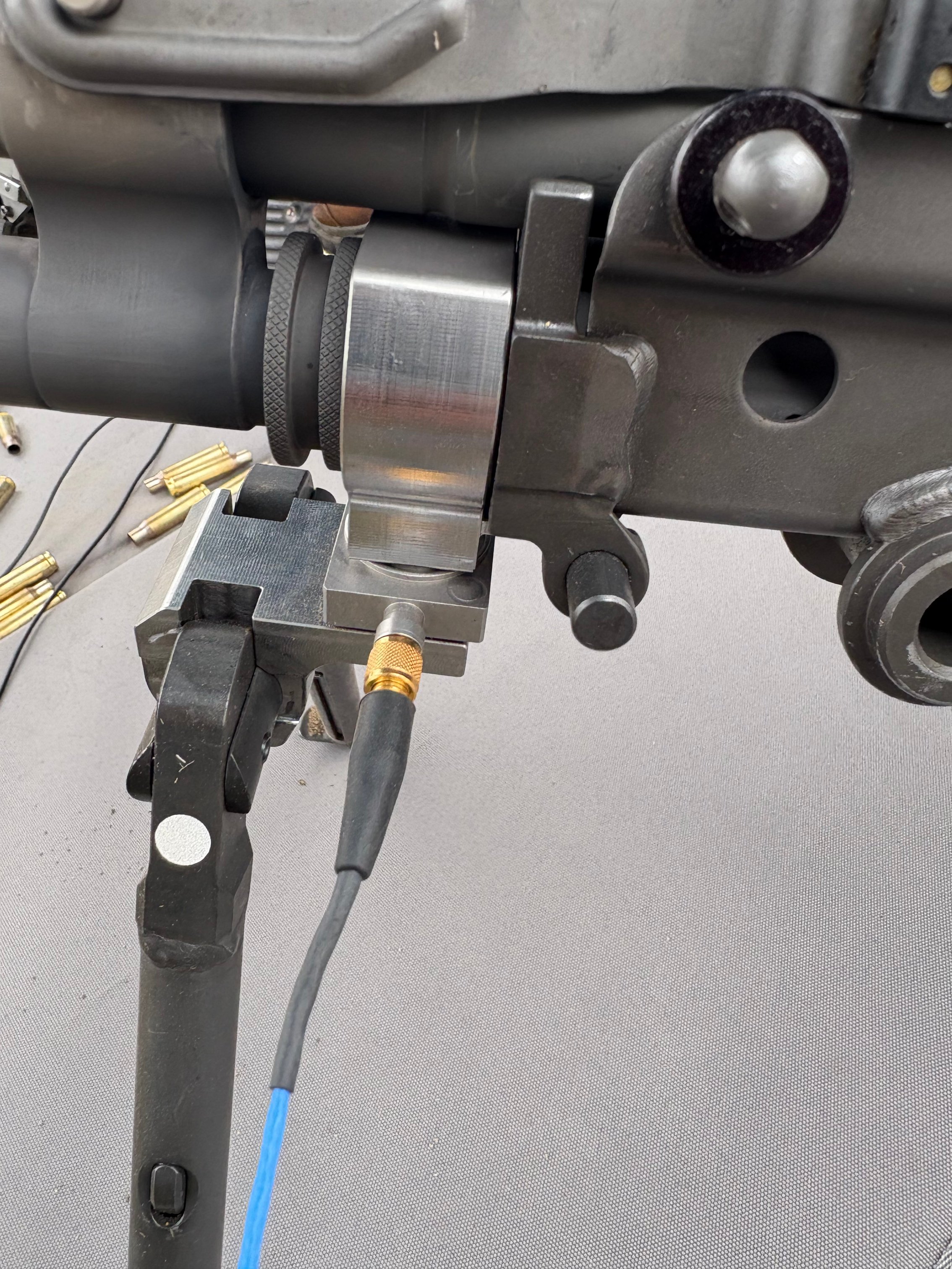 Instrumented firearm bipod with triaxial IEPE/ICP force sensor to measure forces transferred to bipod during shooting.